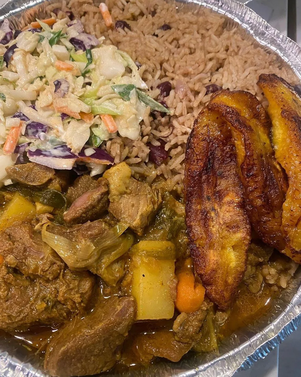 Combo plate with rice and peas, slaw, curry and plantain